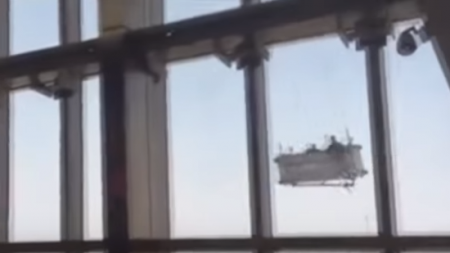 Pe un spălător de geamuri l-a prins o vântoasă la înălțime și l-a învârtit de l-a zăpăcit (VIDEO)
