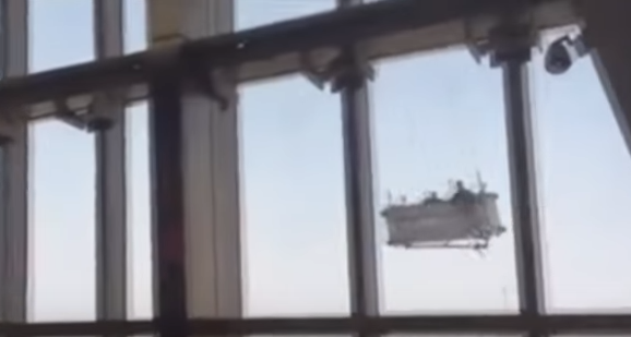 Pe un spălător de geamuri l-a prins o vântoasă la înălțime și l-a învârtit de l-a zăpăcit (VIDEO)