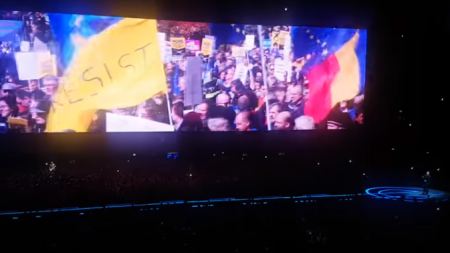 Imagine de la un protest din România într-un montaj ce apare în concertele celebrei trupe U2