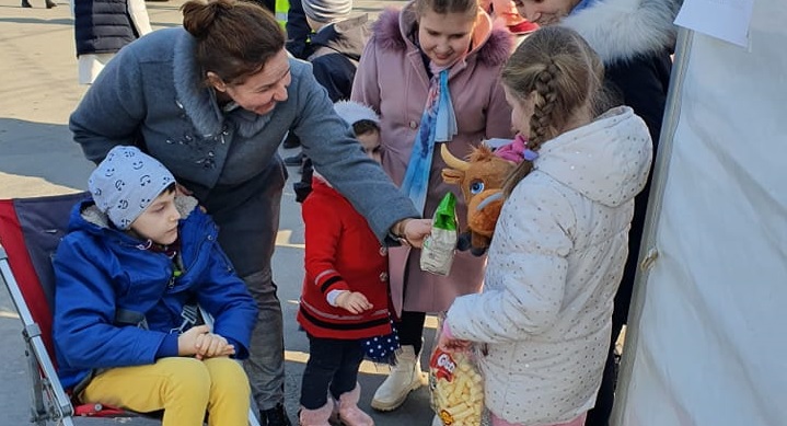 Imaginea bunătății și solidarității: În județul Maramureș un tânăr cu dizabilități aduce fericire copiilor ucraineni, sosiți în Sighet, cu dulciuri și jucării!