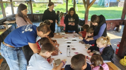 Meșterii populari Ana Mețenti și Viorelia Butcure, alături de copiii prezenți la atelierele de vacanță de la Muzeul Satului Baia Mare